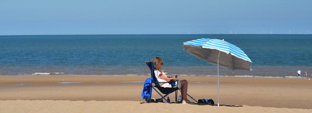 Girl with umbrella on Sutton on Sea Beach